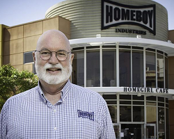 Man standing in front of Homeboy Industries building.