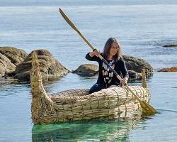 Rumsien Ohlone Linda Yamane paddling a tule boat she made.
