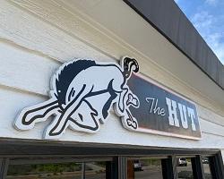 Photo of The Hut sign on the exterior of the building.