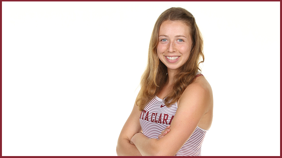 Student standing with her arms crossed.