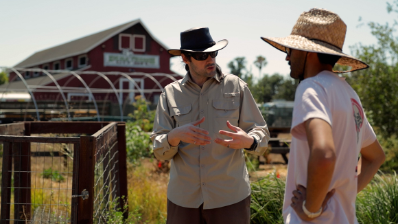 Two men having a discussion at San Jose's Veggielution farm.