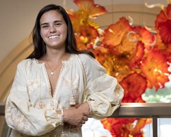 Woman standing in front of a blown glass chandelier.