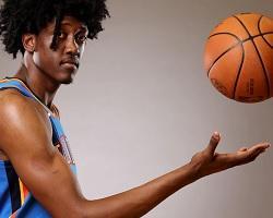 Man tossing a basketball in the air one-handed.