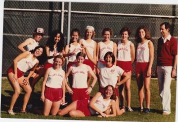 A sports team in red and white uniforms posing together.