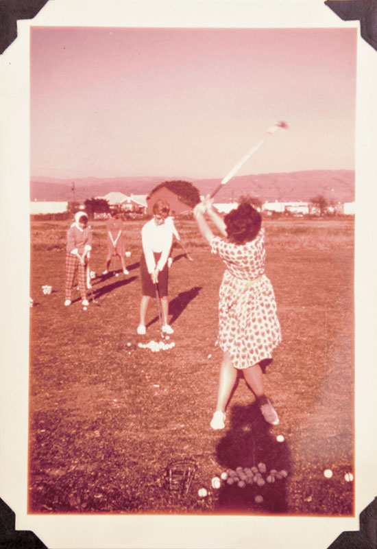 Children playing with a coiled object in a field.