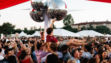 A young man crowd surfing on the outdoor dancefloor at SCUs Grad Bash 2026. 