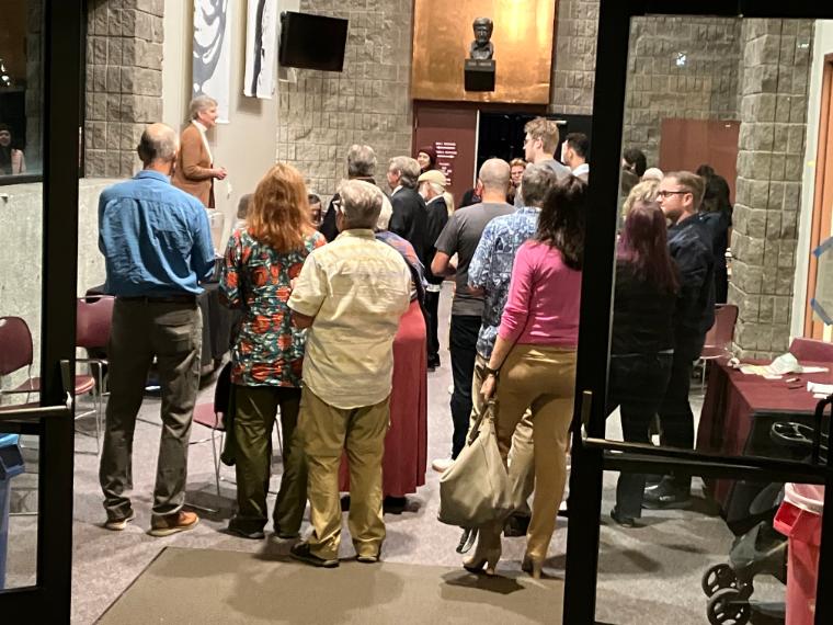 A group of people standing and facing a tour guide in Mayer Theater