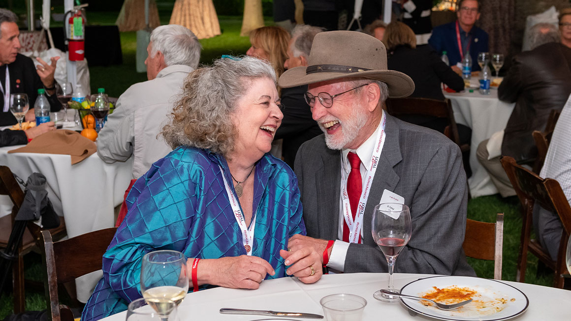 Two people sitting at a table and laughing 
