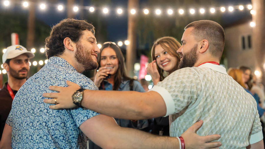 Two men arm in arm at the Block Party 