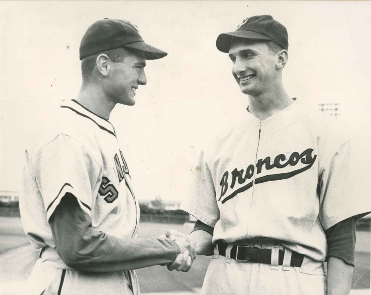 Two baseball players shaking hands, wearing uniforms and caps, George Stein HOF.