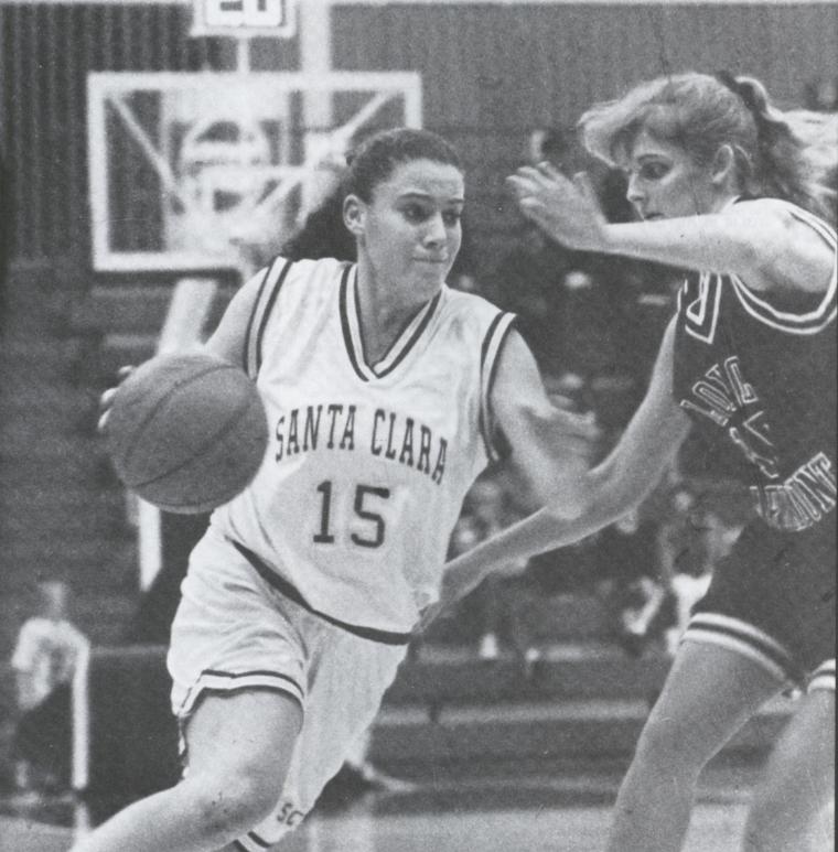 Black-and-white photo of two women playing basketball.