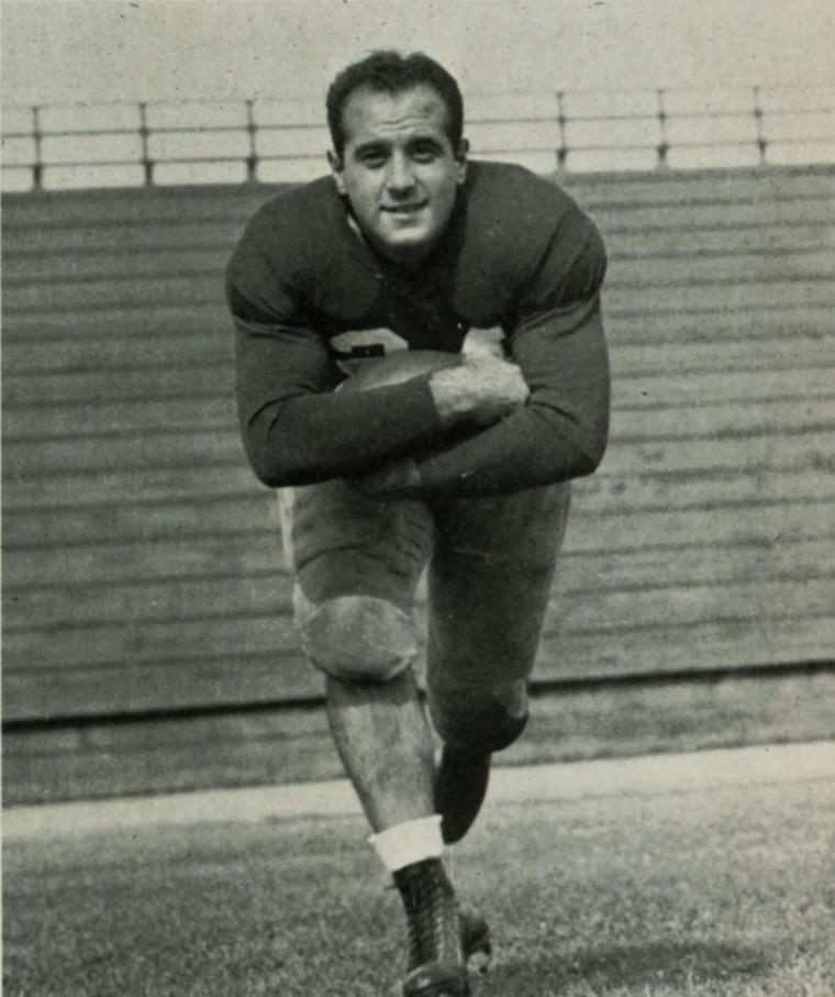 A football player running with a ball, mid-action.