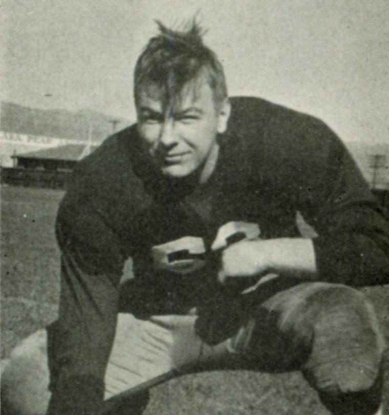 A vintage photograph of a football player in uniform.