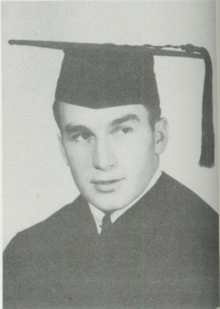 Black and white portrait of a young man in a graduation cap.