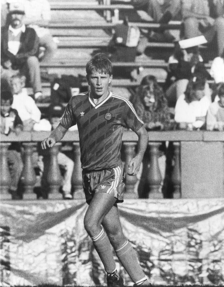 Black-and-white photo of a soccer player in action on the field.