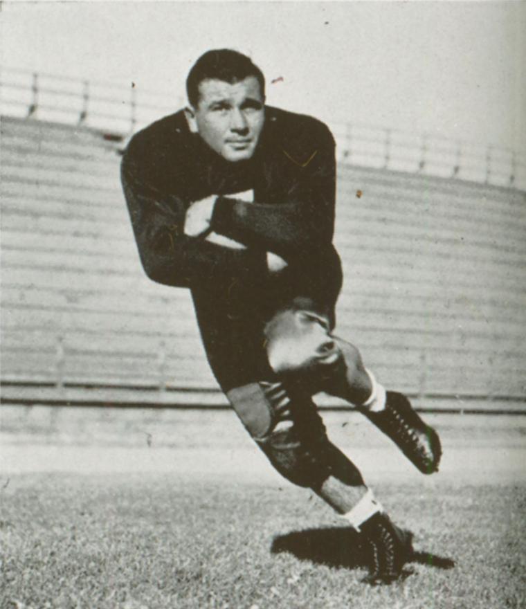 A football player in uniform running on the field.