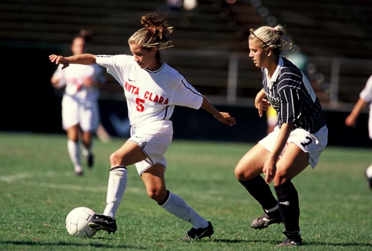 Two soccer players competing for the ball on the field.