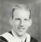 A person wearing graduation attire, smiling for a formal portrait.