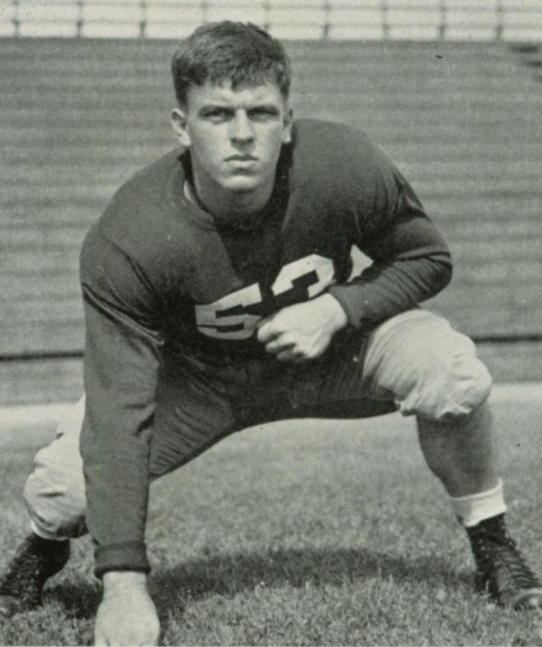 Black and white photo of football player in a crouched stance.