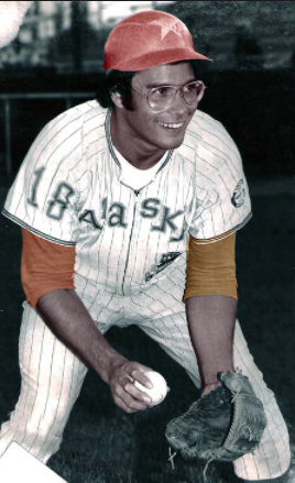 Person in a baseball uniform holding a ball and a glove.