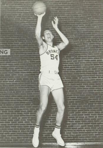 Basketball player in mid-shot wearing jersey number 11 in a vintage photograph.