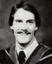 A person in graduation attire smiling at the camera.
