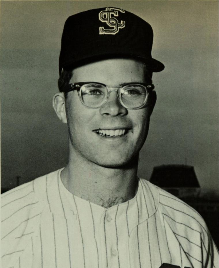A man in a baseball uniform and cap, titled J. Robert Spence.