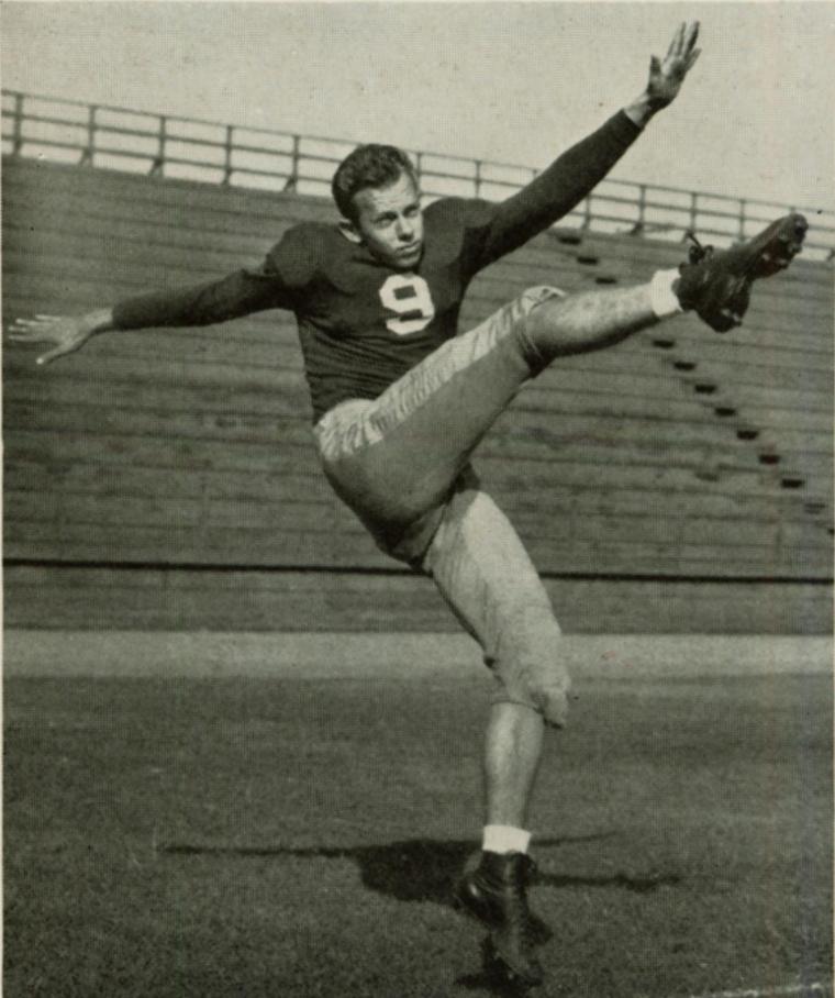 A football player in a jersey kicking a ball.