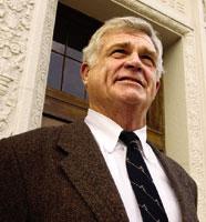 A person in a suit standing in front of a building.