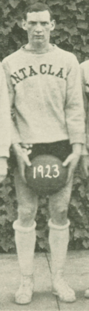 A man in a football uniform holding a ball, dated 1922.
