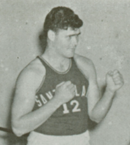 Man wearing a basketball jersey with the number 12, posing in a fighting stance.