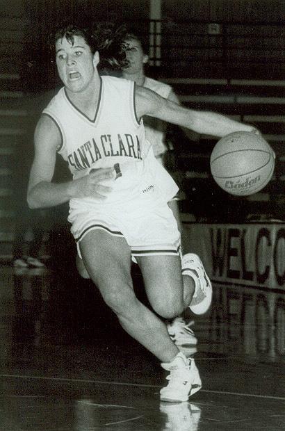 A basketball player dribbling the ball on a court in uniform.