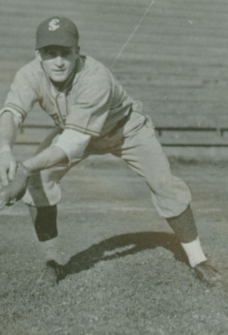 Black and white photo of a baseball player fielding a ball.