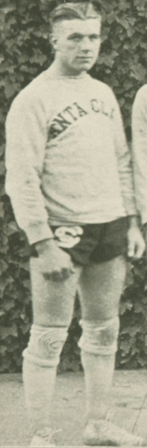 A man in an athletic uniform looking at the camera, black and white photograph.