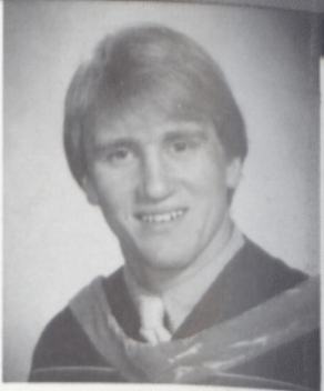 Black-and-white portrait of a person in graduation attire for Philip Russik HOF.