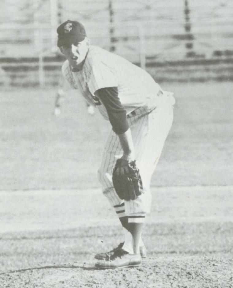 A baseball player preparing to pitch on a field (1966).