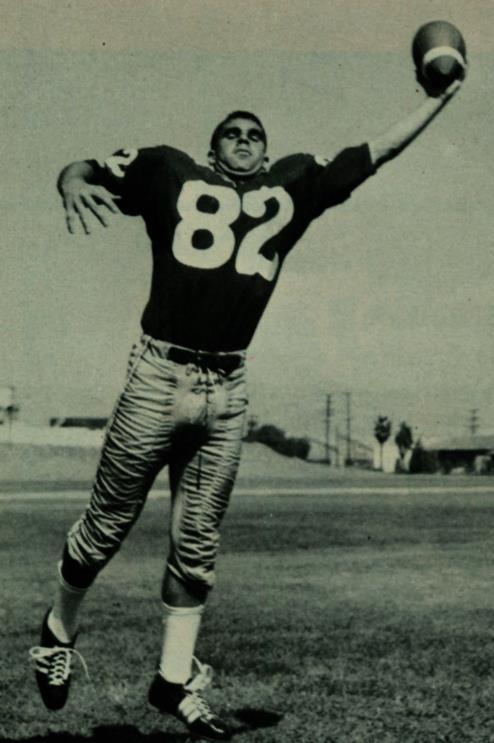 Football player #82 catching the ball in action, black and white photograph.