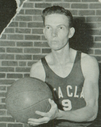 A black and white photo of a basketball player with a ball.