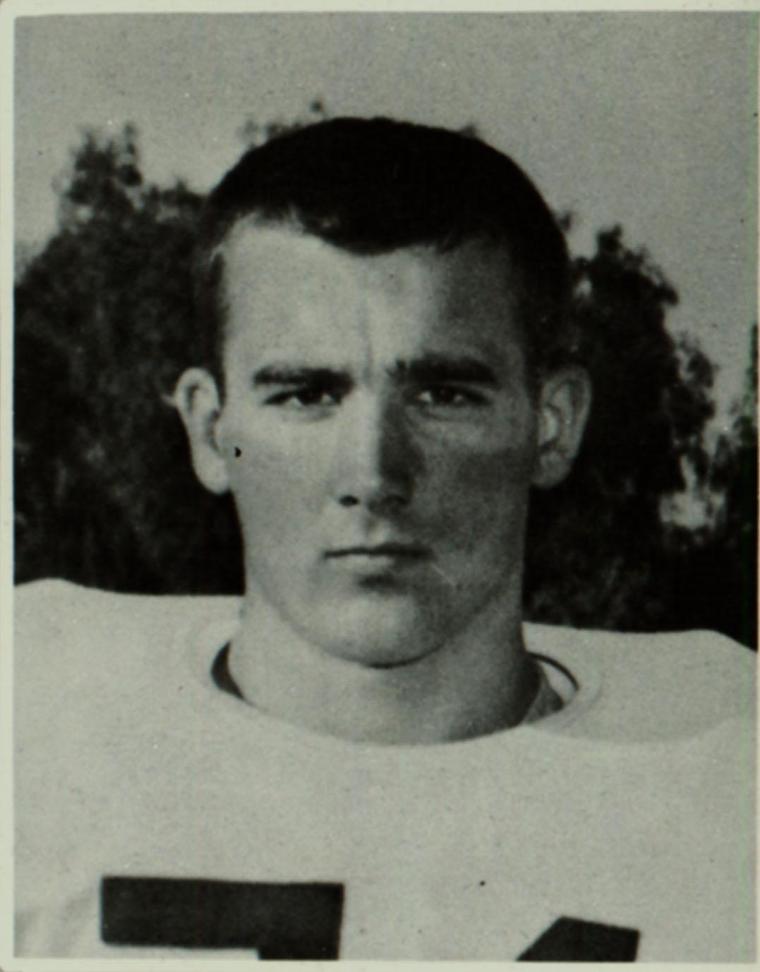 Black and white photo of an athlete in a football uniform.