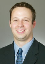 A person in a suit and tie smiling.