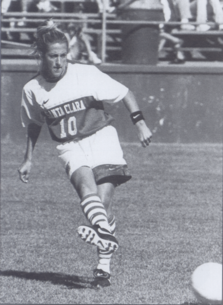 A soccer player running and controlling the ball.