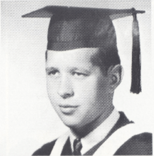 Black and white portrait of a man in a graduation cap and gown.