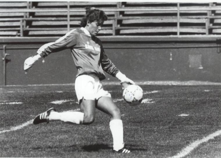 A soccer player kicking a ball on a field.