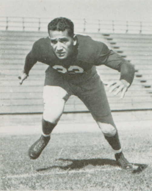 A football player in a ready stance on a field.