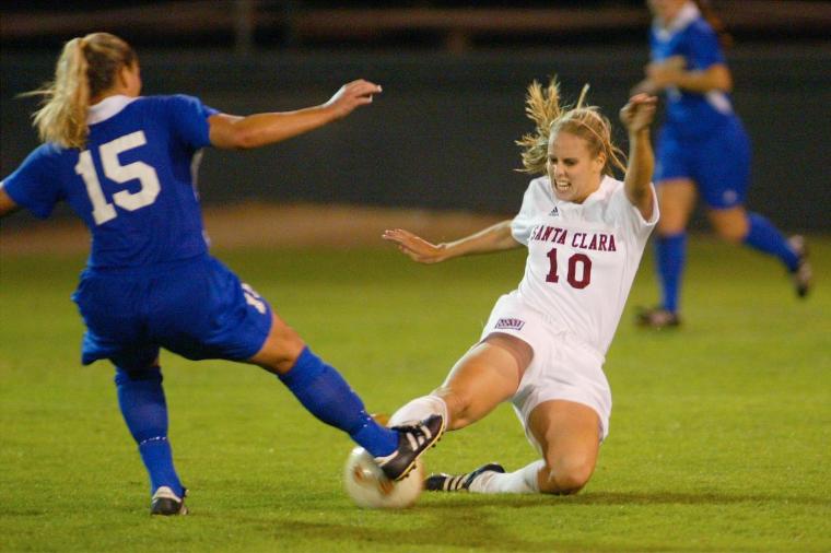 Two soccer players during a game, one in blue (#15) and one in white (#12).