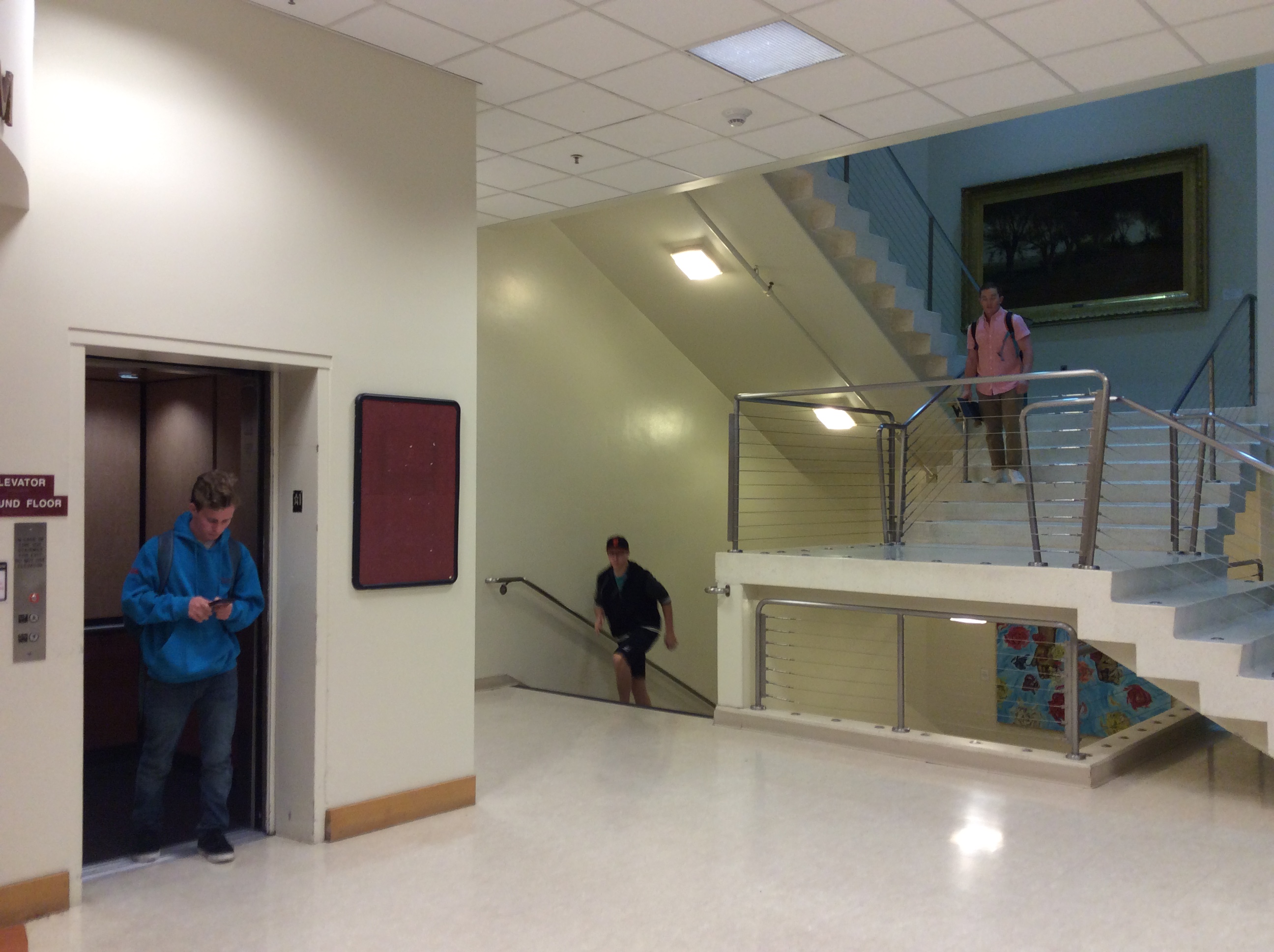 Two people in a hallway, one walking towards stairs. image link to story