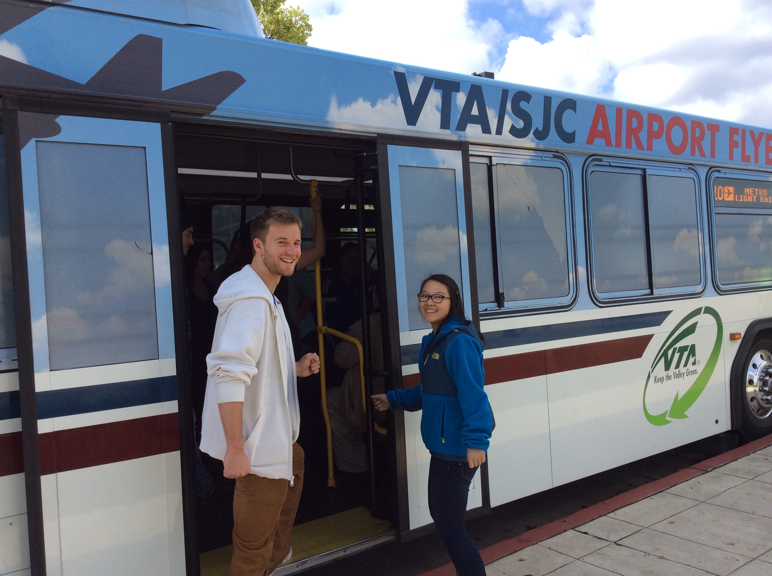 Two people boarding a bus at a bus stop. image link to story