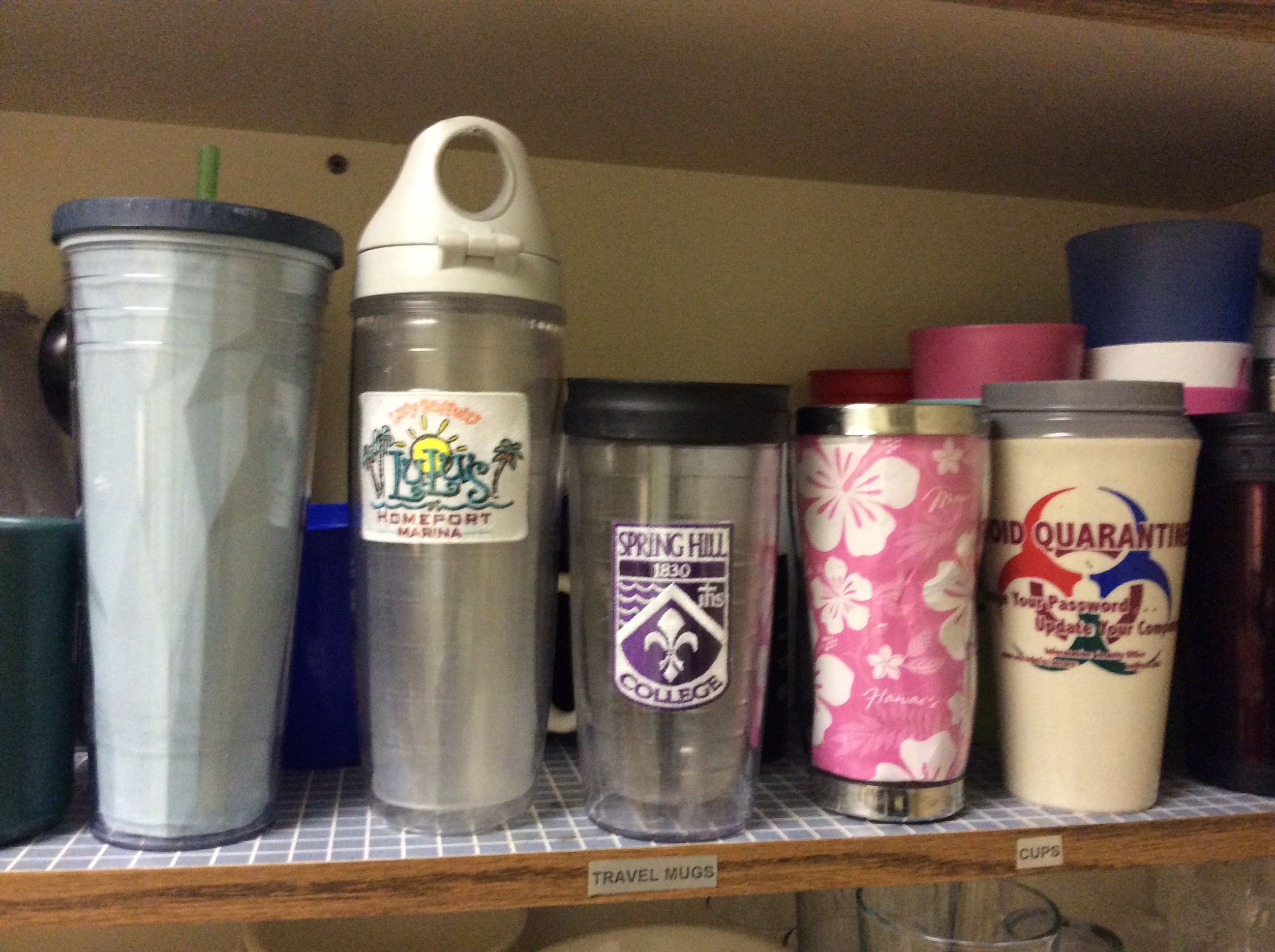 Reusable coffee mugs in various designs and colors on a shelf. image link to story