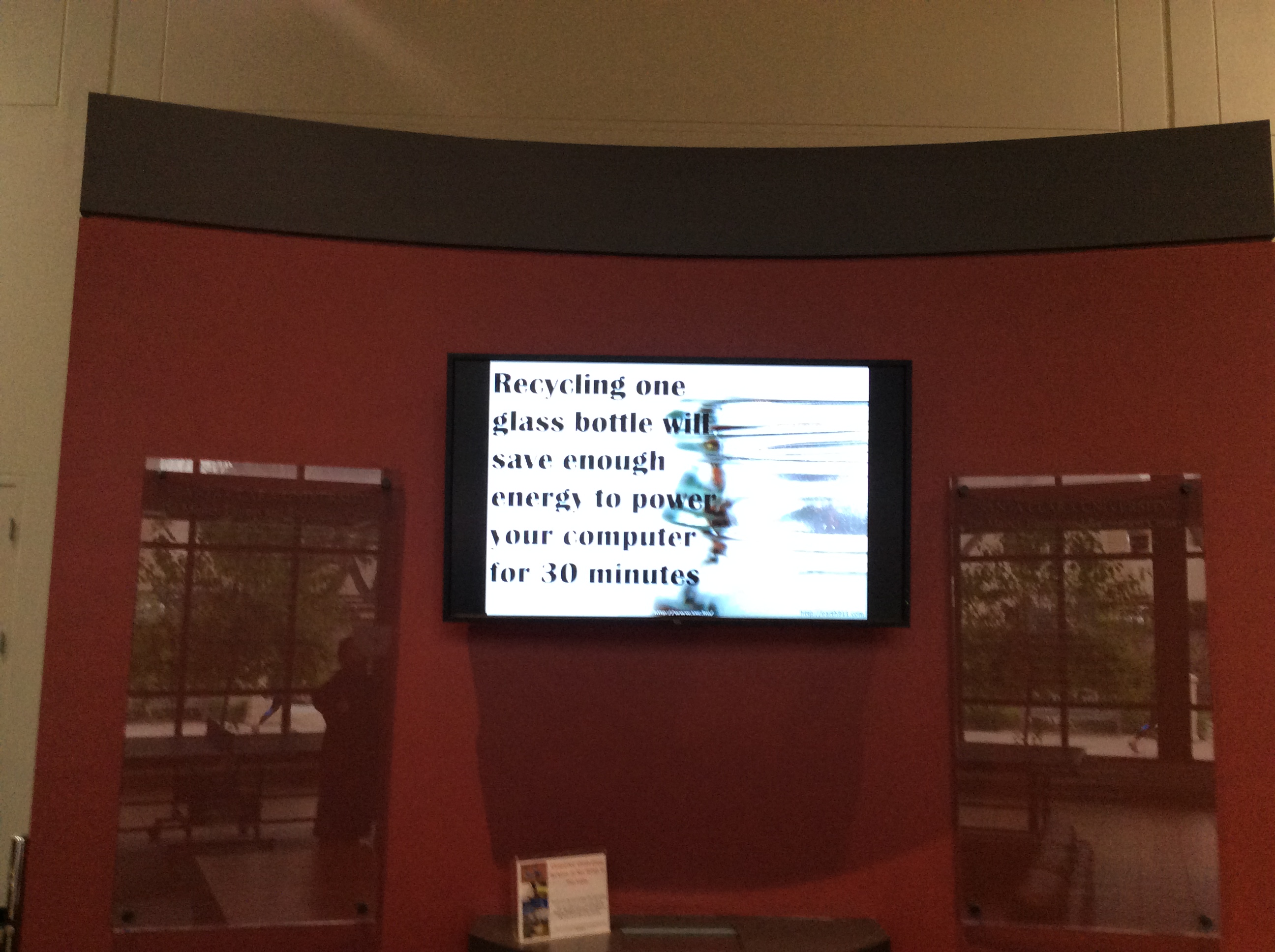 Alt text: Display of reusable water bottles on shelves beneath an illuminated screen. image link to story