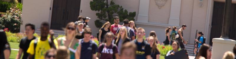 Student walking on campus with Mission Church in background 